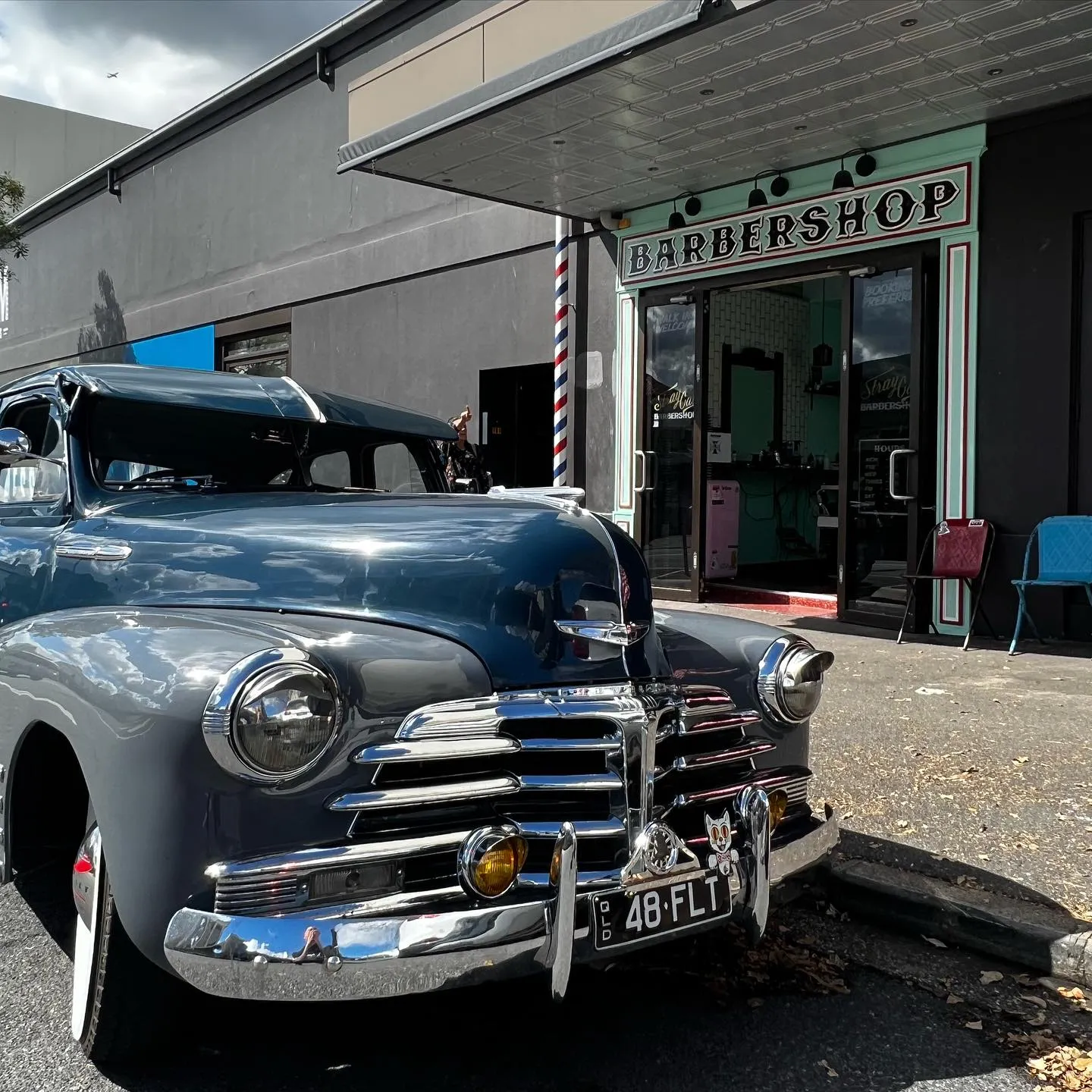 Vintage car parked outside Straycat Barbershop